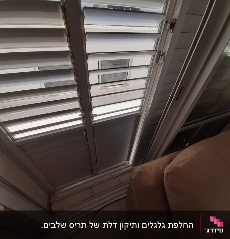תריסים לבנים פתוחים למחצה עם מנגנון סגירה